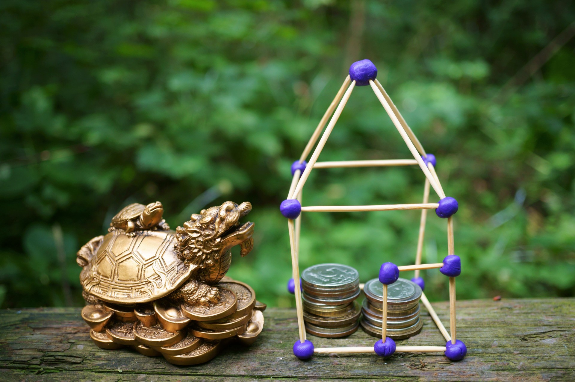A toy house made of matches with coins.